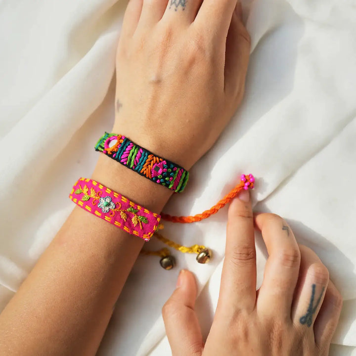Handmade Embroidered Floral Rabari Rakhi With Roli Chawal Set Of 2 - Bracelets Being Adjusted on Wrist