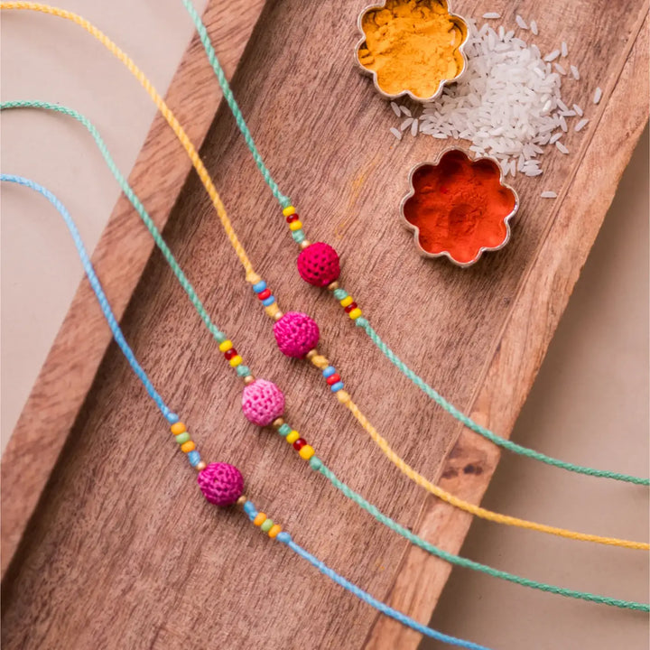 Handmade Crochet Yellow Beads Rakhi With Roli Chawal Set Of 4 - Full set with spices on wooden tray