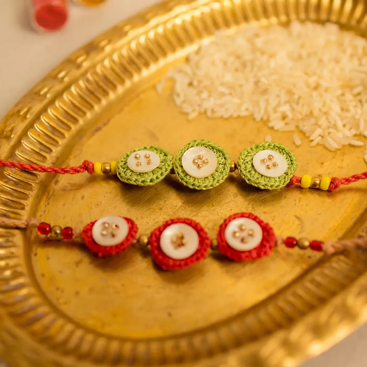 Handmade Crochet Ananta Rakhi With Roli Chawal Set Of 2 - Close-up of two bracelets on tray