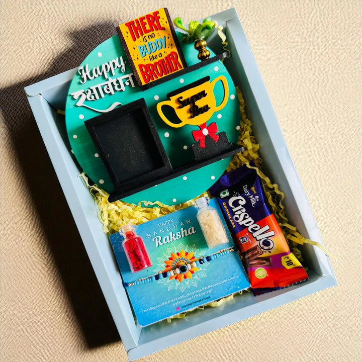 Photo Personalized Super Bro Mdf Wood Rakhi Hamper With Chocolates And Roli Chawal Includes 1 Fridge Magnet 1 Rakhi - Angled View of Gift Box Contents