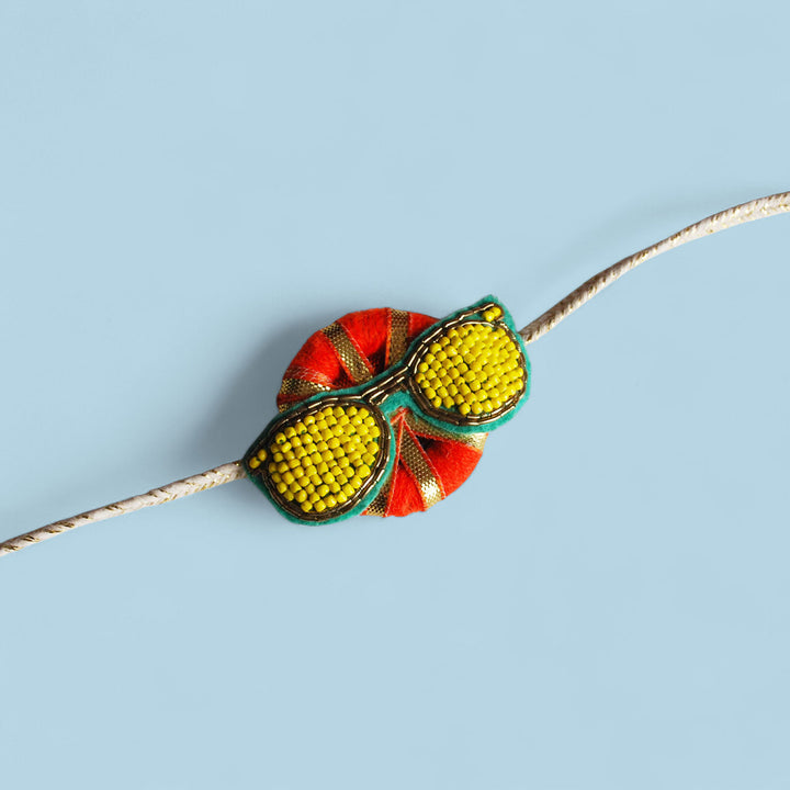 Handmade Reusable Chashma Pom Pom Felt Kids Rakhi - Close-up with Blue Background