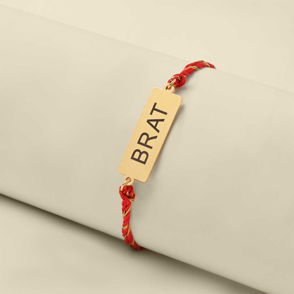 Handmade Brat Design Metal Rakhi - Bracelet Displayed on Rolled Surface