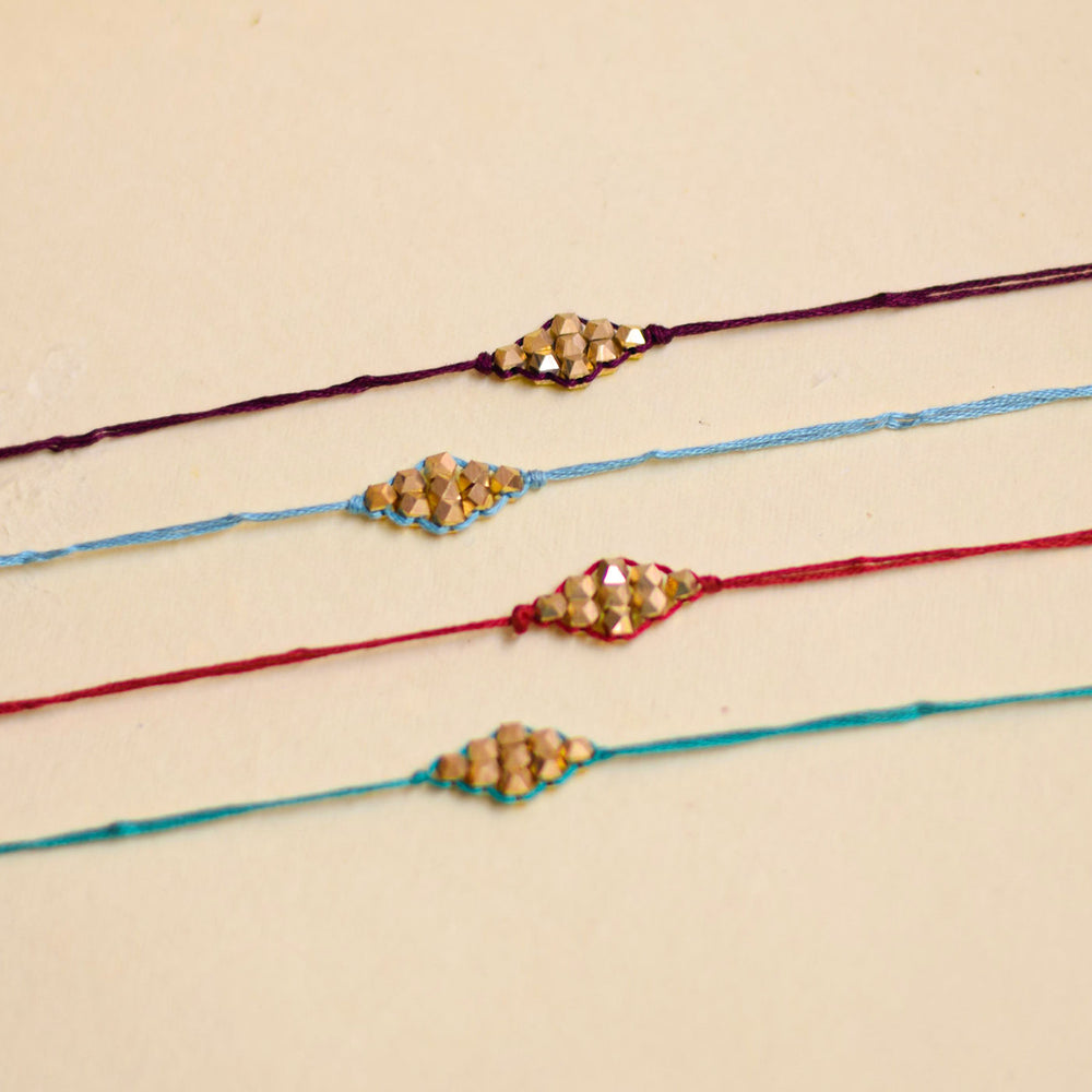 Handmade Sunehra Bandhan Rakhi With Roli Chawal - Top-down view of four bracelets