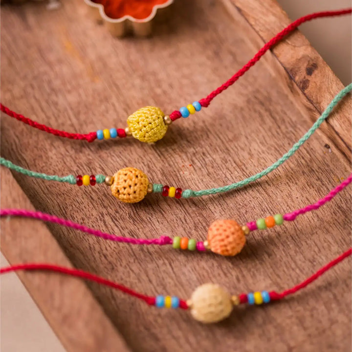 Handmade Crochet Yellow Beads Rakhi With Roli Chawal Set Of 4 - Close-up of yellow and orange beads