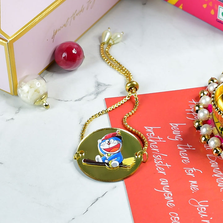 Doraemon Acrylic Bracelet Rakhi Hamper With Chocolates And Roli Chawal For Brother Customizable Options Includes Up To 7 Goodies - Bracelet on Display Surface