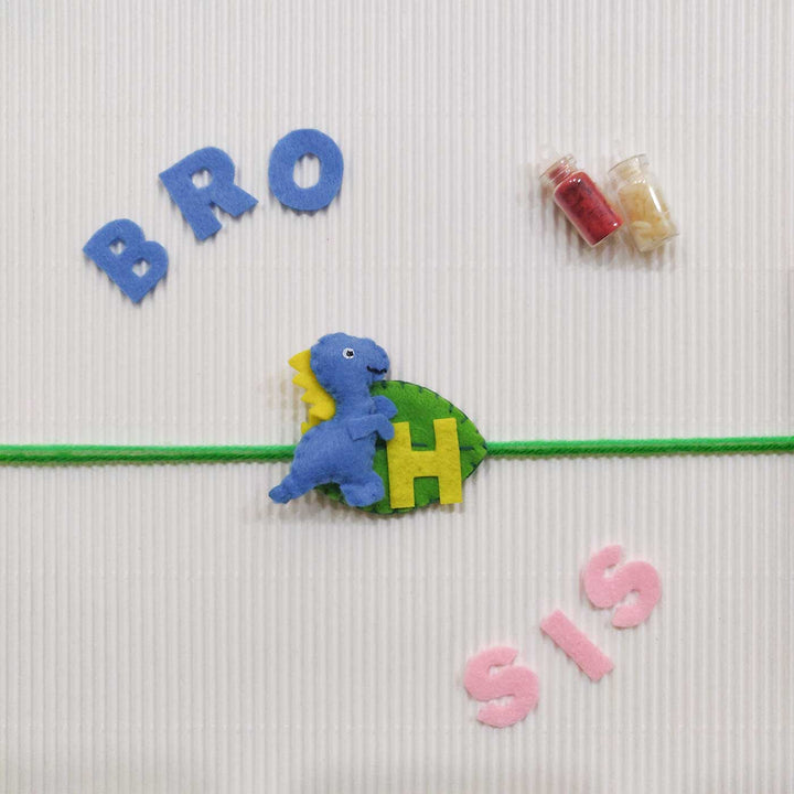 Personalized Handmade Dinosaur Theme Felt Kids Rakhi With Roli Chawal - Blue dinosaur wristband with letters