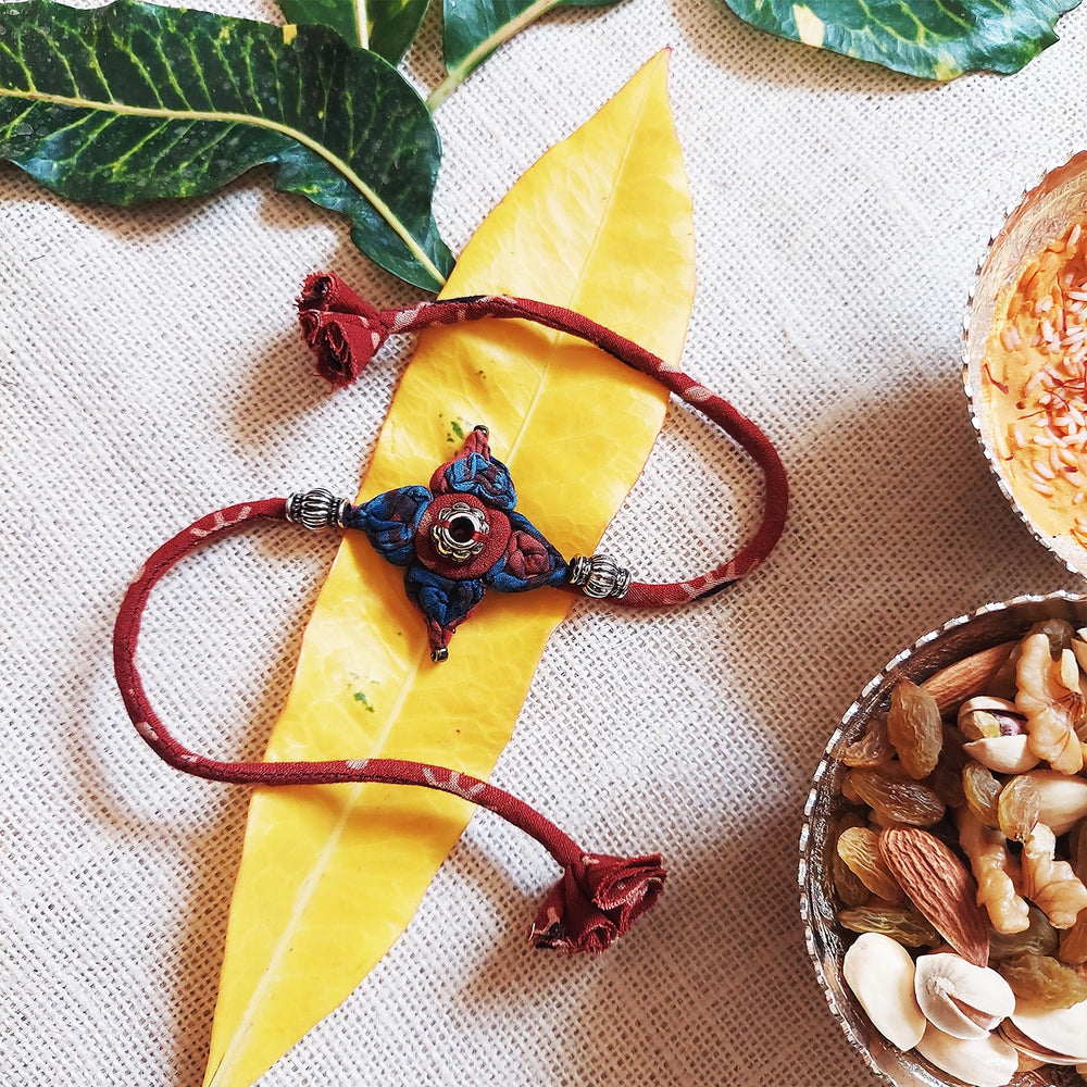 Handmade Dori Work Flower Ajrakh Rakhi With Roli Chawal - Styled with Natural Elements