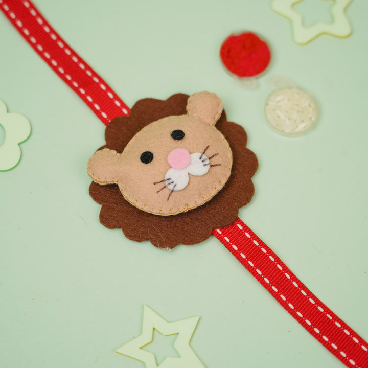 Handmade Lion Theme Felt Kids Rakhi With Roli Chawal - Flat Lay with Ribbon Extended