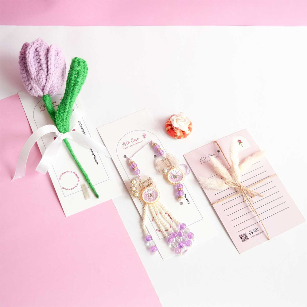 Personalized Handmade Crochet Tulip Light Purple Rakhi Hamper Includes 1 Crochet Flower 1 Message Card And 2 Rakhis And Roli Chawal - Angled Flat Lay Arrangement