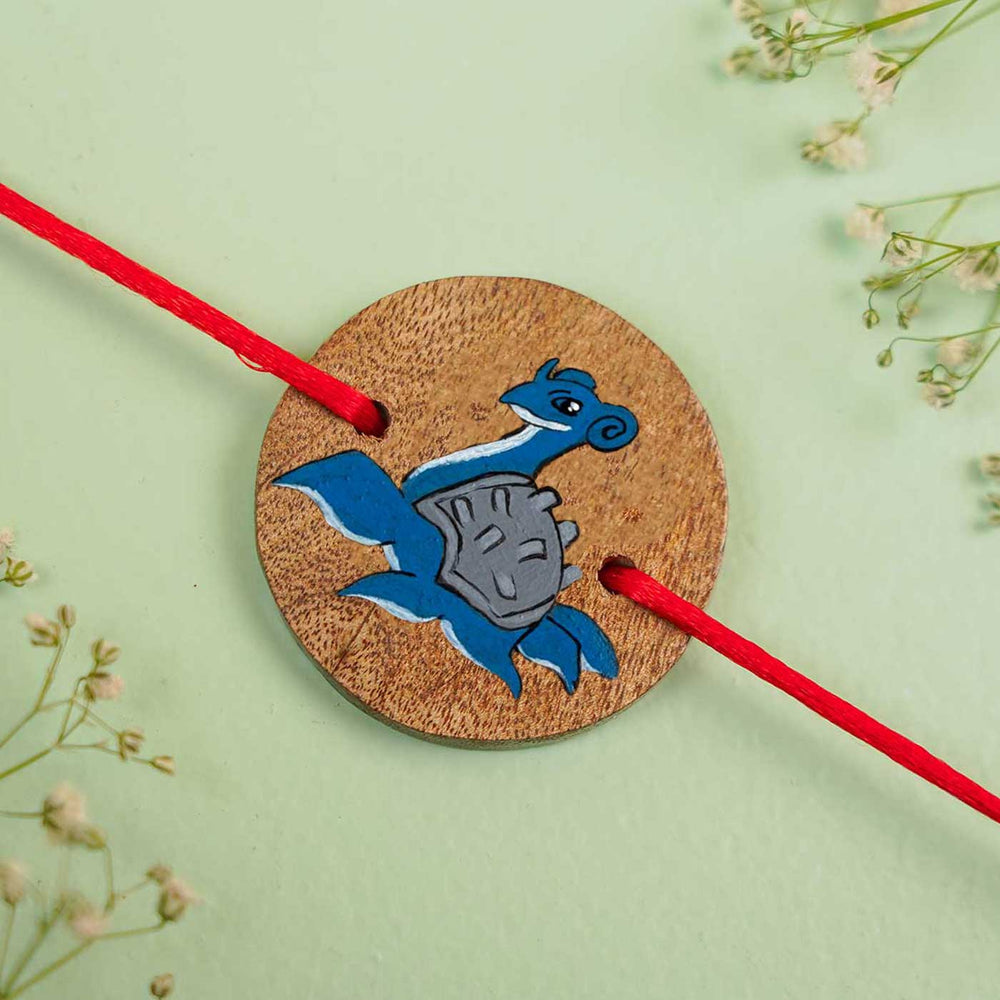 Personalized Hand Painted Lapras Wooden Rakhi With Roli Chawal - Flat Lay View