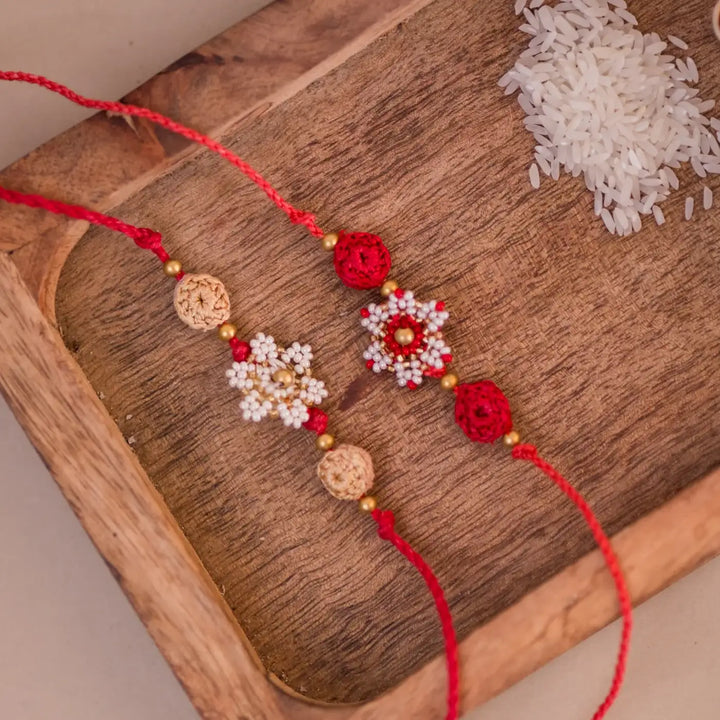 Handmade Crochet Red And White Flower Rakhi With Roli Chawal Set Of 2 - Close-up of two bracelets