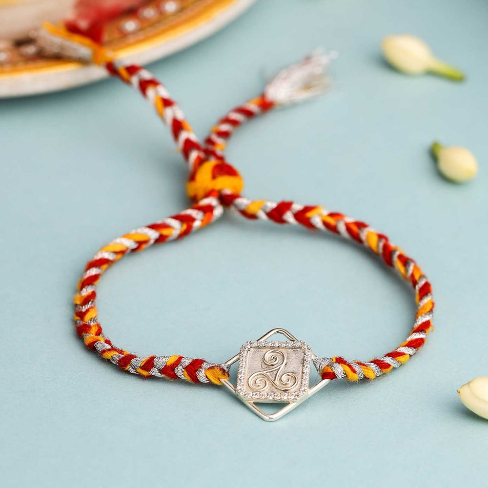 Handmade Three Swirl Design Silver Rakhi For Brother - Bracelet on flat surface
