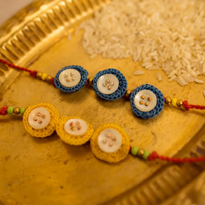 Handmade Crochet Ananta Rakhi With Roli Chawal Set Of 2 - Close-up of two blue and yellow bracelets