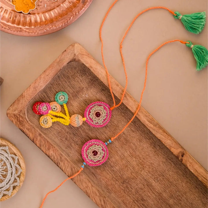 Handmade Crochet Pink Mandala Bhaiya Bhabhi Rakhi With Roli Chawal Set Of 2 - Flat Lay Showing Both Decorative Pieces