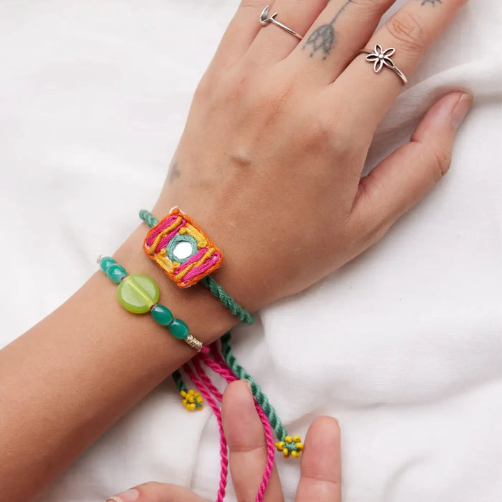 Handmade Beaded And Mirror Work Litchi Rakhi With Roli Chawal Set Of 2 - Top View Showing Bracelets on Wrist