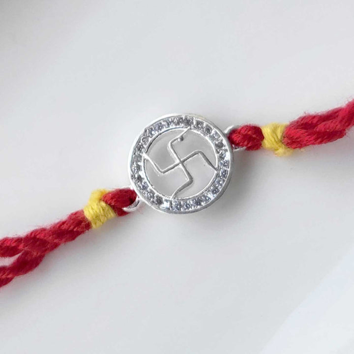 Handmade Swatik Design Silver Rakhi Hamper With Roli Chawal For Brother - Close-up of Rakhi centerpiece