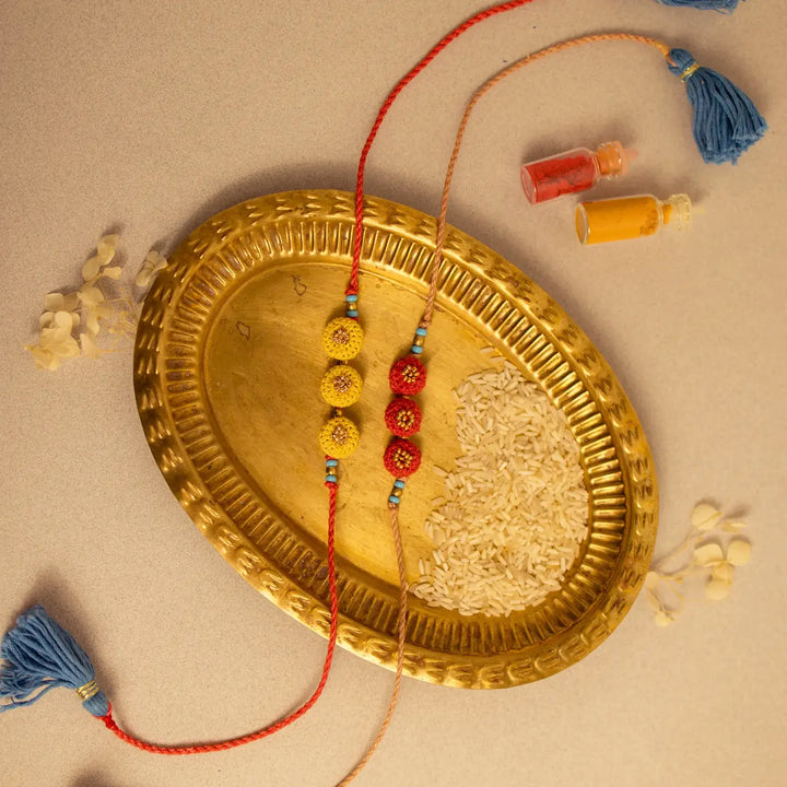 Handmade Crochet Round Ananta Rakhi With Roli Chawal Set Of 2 - Top angle showing tassels