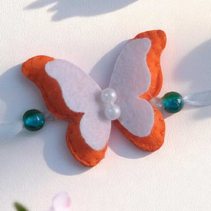Customized Handmade Beaded Butterfly Theme Pom Pom Felt Rakhi With Roli Chawal For Kids - Close-up of Butterfly Detail
