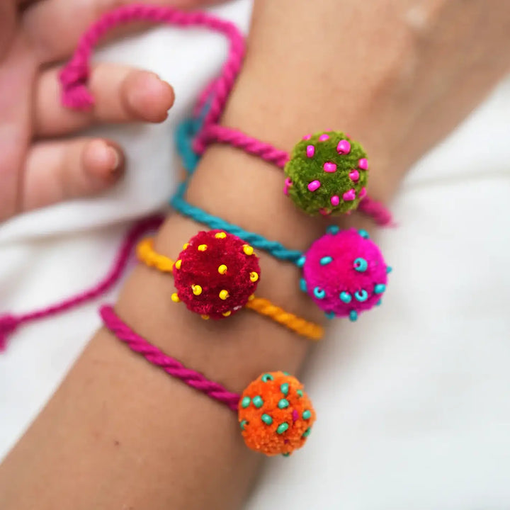 Handmade Beaded Pom Pom Mini Laddoo Rakhi With Roli Chawal Set Of 4 - Close-up on Wristwear Details