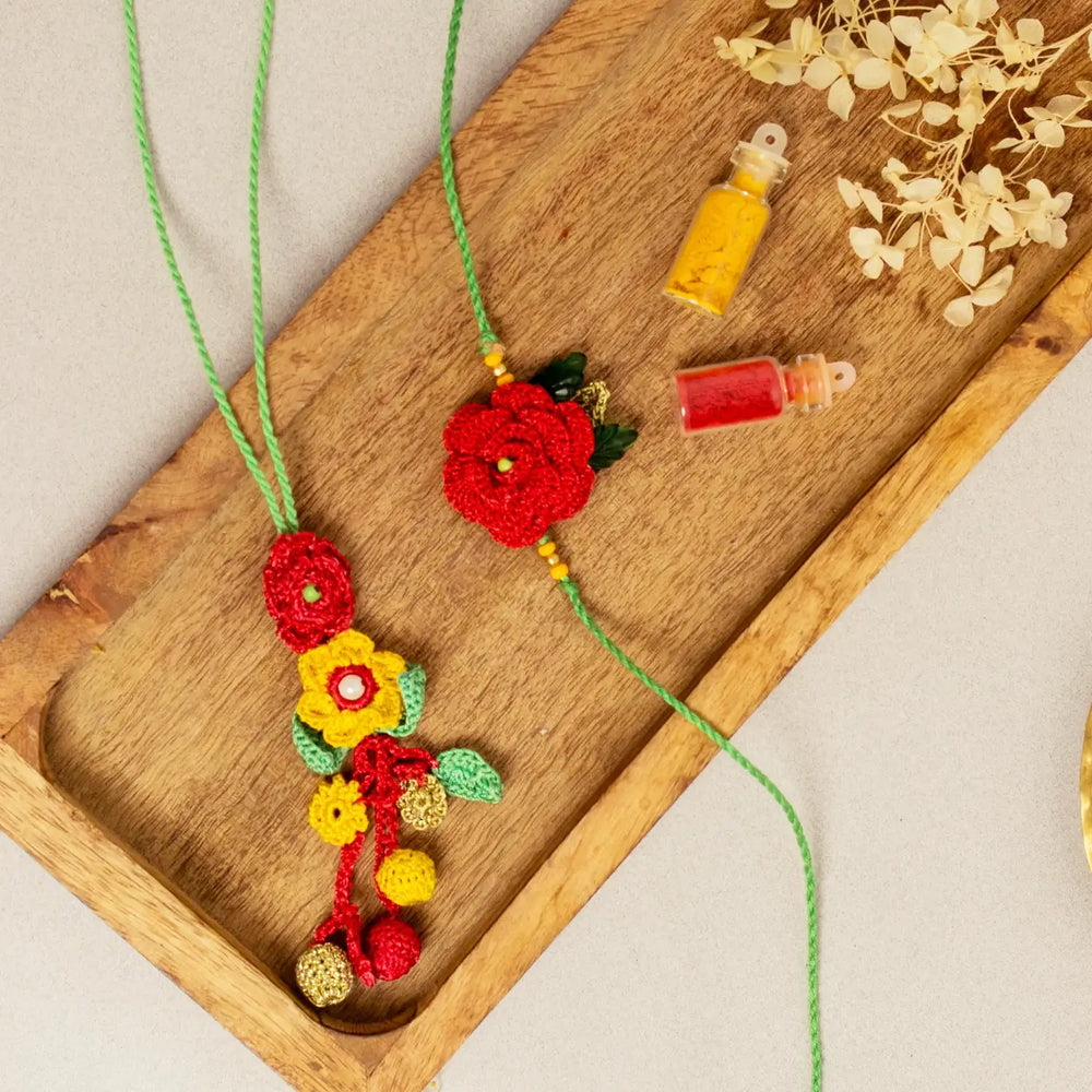 Handmade Crochet Surkh Gulab Bhaiya Bhabhi Rakhi With Roli Chawal Set Of 2 - Top-down view with decor