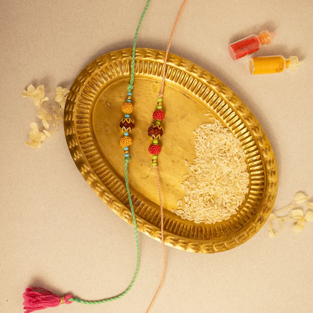 Handmade Crochet Rudraksh Rakhi With Roli Chawal Set Of 2 - Flat Lay with Rakhi and Accessories