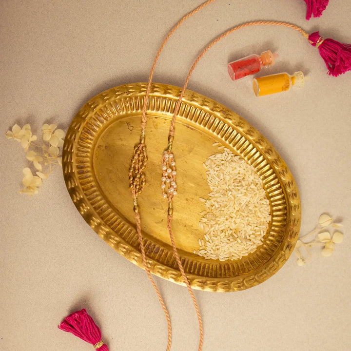 Handmade Crochet Noori Moti Rakhi With Roli Chawal Set Of 2 - Flat lay with decorative items