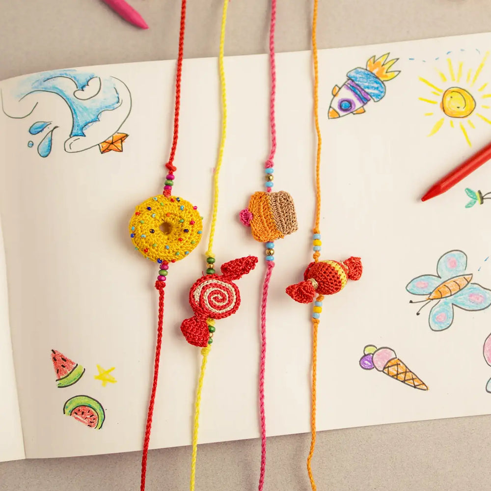 Handmade Crochet Candy Theme Rakhi With Roli Chawal Set Of 4 - Bracelets Display on White Paper
