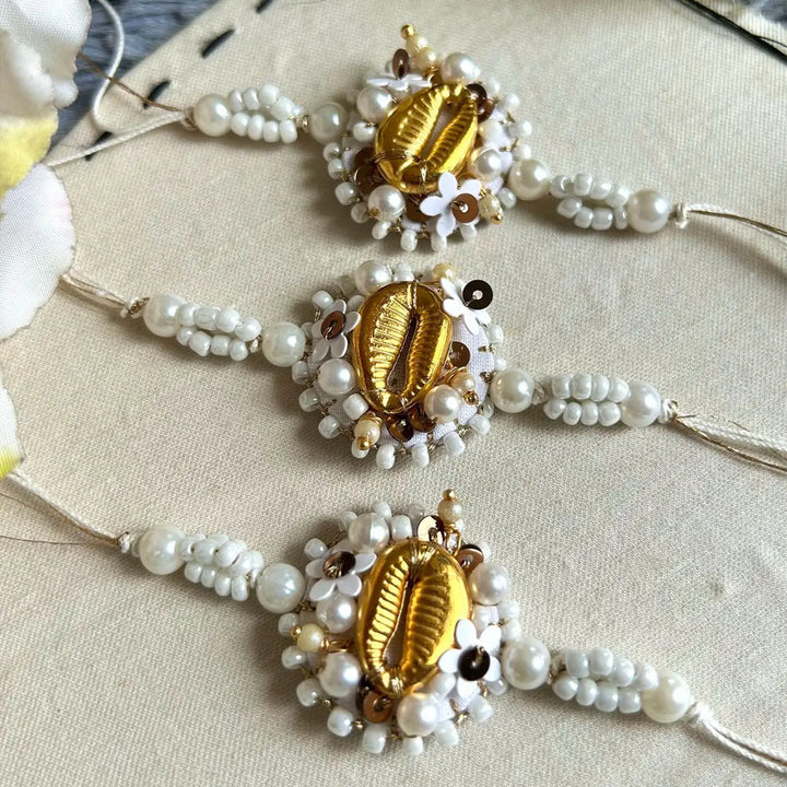 Hand Embroidered Beaded Golden Shell Bhaiya Bhabhi Rakhi With Roli Chawal Set Of 2 - Top View Flat Lay