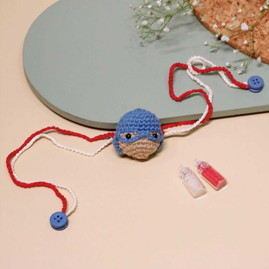 Handmade Crochet Captain America Kids Rakhi With Roli Chawal - Laid Flat with Accessories
