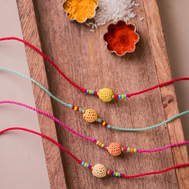 Handmade Crochet Yellow Beads Rakhi With Roli Chawal Set Of 4 - Top view of colorful bead strings