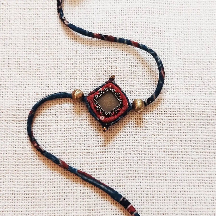 Handmade Dori Work Antique Ajrakh Rakhi With Roli Chawal - Close-up of main pendant detail