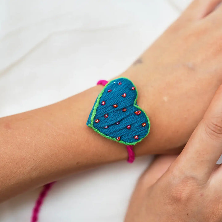 Handmade Mirror Work And Embroidery Only Love Rakhi With Roli Chawal Set Of 3 - Close-up Wrist View of Heart Bracelet