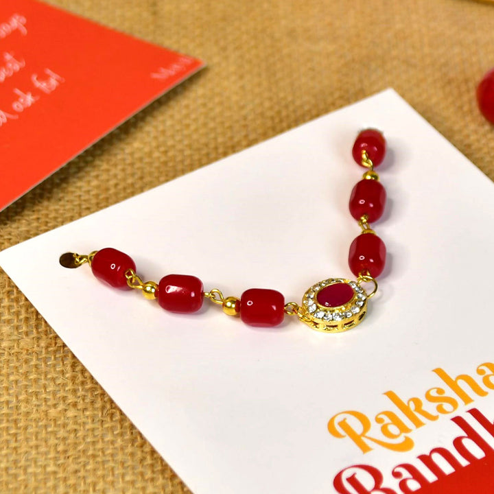 Beaded Red Pearl And Stone Bracelet Rakhi Hamper With Chocolates And Roli Chawal For Brother Customizable Options Includes Up To 7 Goodies - Close-up of Rakhi bracelet