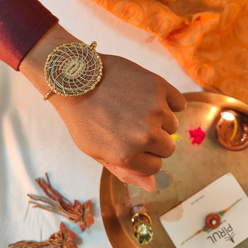 Eco Friendly Handmade Gold Beads Pine Needle Rakhi With Pouch And Roli Chawal - On Wrist Styled View