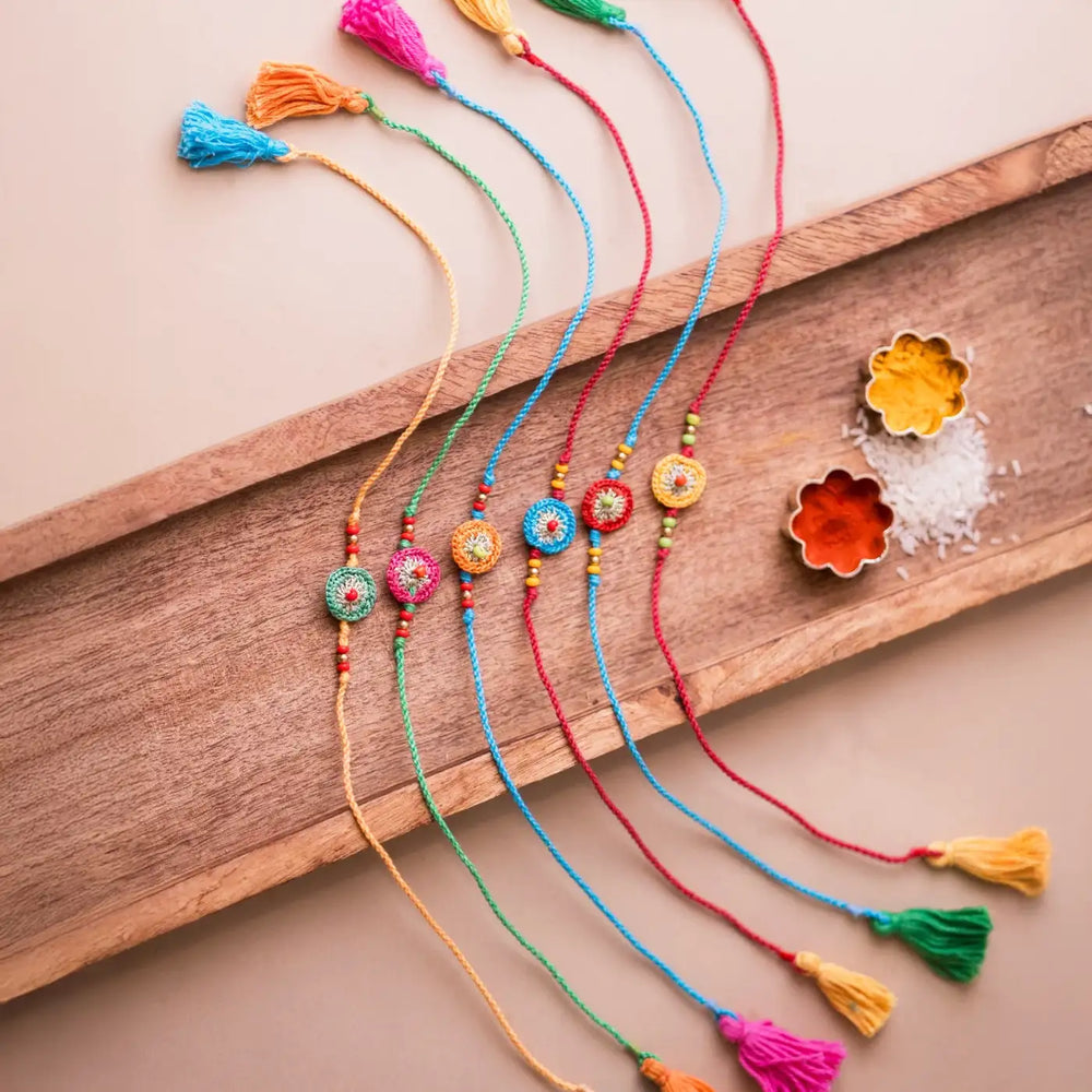 Handmade Crochet Multicolor Round Rakhi With Roli Chawal Set Of 6 - Top View with Decorative Spices