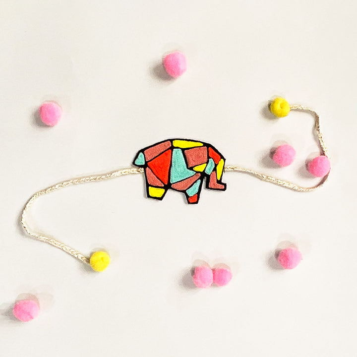 Handmade Reusable Elephant Theme Pom Pom Felt Rakhi For Brother - Flat Lay with Decorative Elements