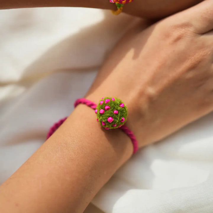 Handmade Embroidered And Beaded Pom Pom Toli And Laddoo Rakhi With Roli Chawal Set Of 2 - Close-up of Round Bracelet