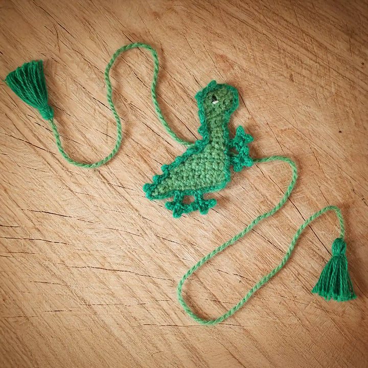 Handmade Crochet Dino Theme Kids Rakhi And Toy Combo With Roli Chawal Set Of 2 - Flat Layout of Crochet Dinosaur Bookmark
