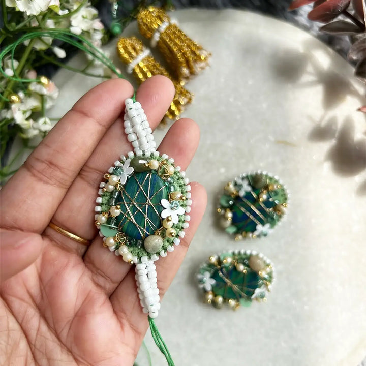 Hand Embroidered Beaded Moni Bhaiya Bhabhi Rakhi With Roli Chawal Set Of 2 - Close-up of Necklace in Hand