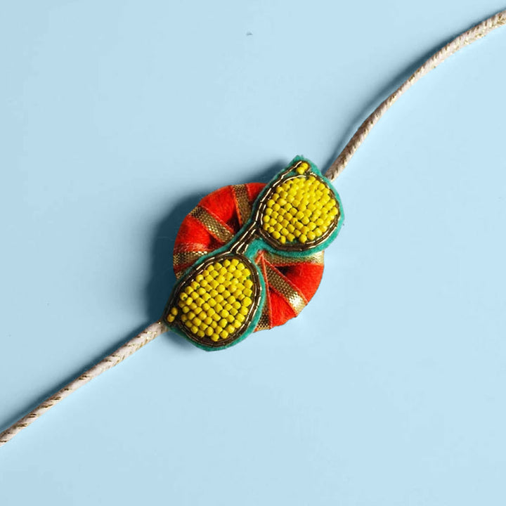 Handmade Reusable Chashma Pom Pom Felt Kids Rakhi - Side Angle with Blue Background