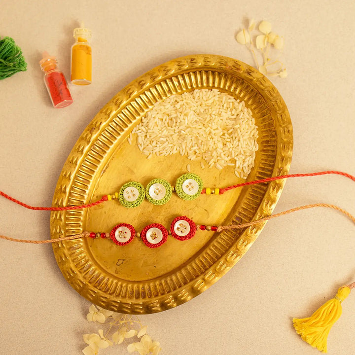 Handmade Crochet Ananta Rakhi With Roli Chawal Set Of 2 - Flat lay with two contrasting bracelets