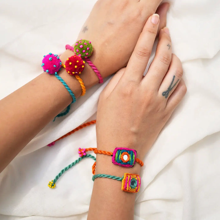 Handmade Embroidered And Beaded Mini Laddoo And Aaina Rakhi With Roli Chawal Set Of 5 - Bracelets on wrists overview