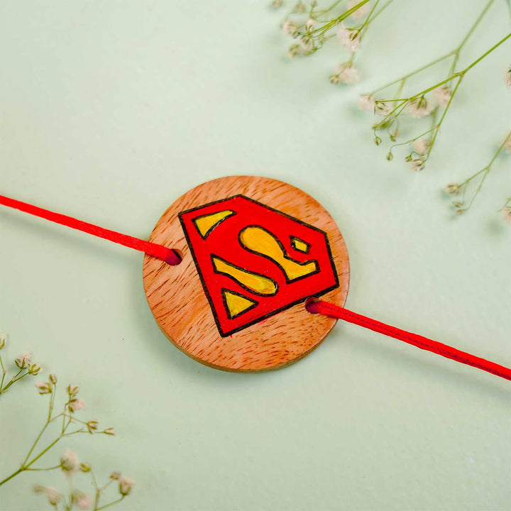 Personalized Hand Painted Super Man Wooden Rakhi With Roli Chawal - Flat Lay Close-up