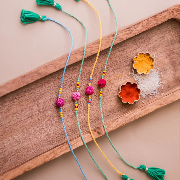 Handmade Crochet Yellow Beads Rakhi With Roli Chawal Set Of 4 - Full set with tassels on tray