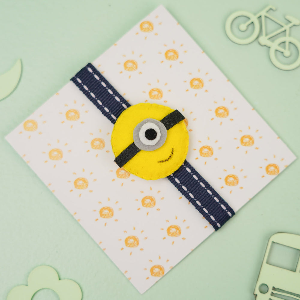 Handmade Minion Theme Felt Kids Rakhi With Roli Chawal - Front View on Card backing