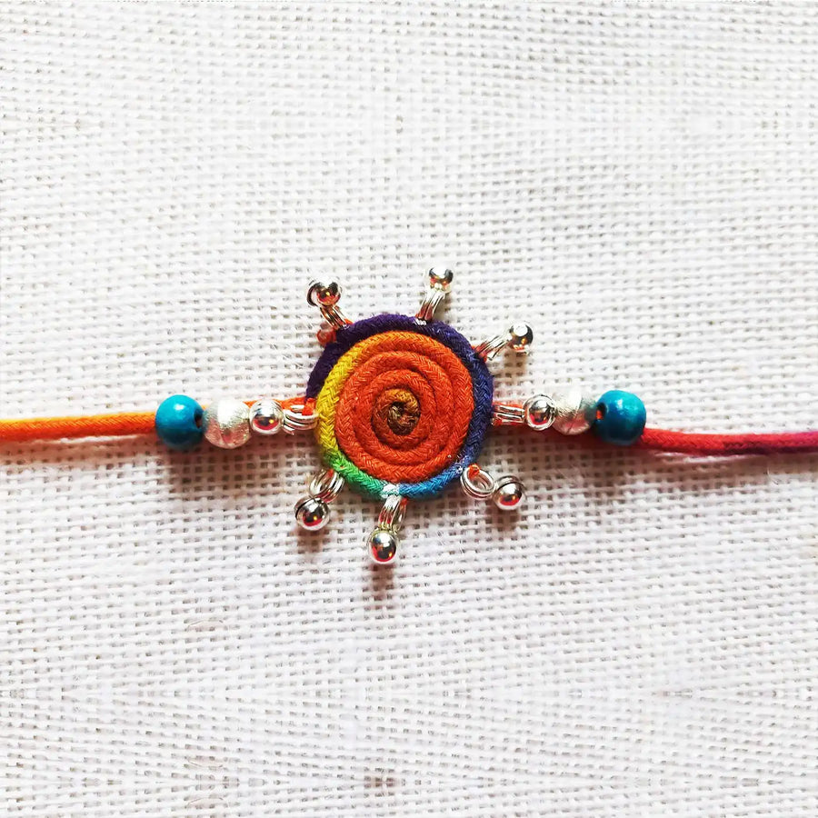 Handmade Dori Work Round Multicolor Gunghroo Rakhi With Roli Chawal - Close-up of Rakhi Centerpiece