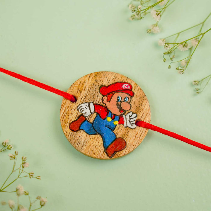 Personalized Hand Painted Mario Wooden Rakhi With Roli Chawal - Close-up with Floral Background