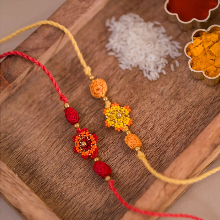 Handmade Crochet Red And Yellow Flower Rakhi With Roli Chawal Set Of 2 - Close-up of Decorative Threaded Bracelets