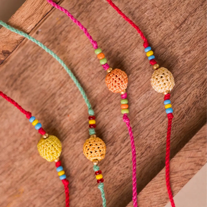 Handmade Crochet Yellow Beads Rakhi With Roli Chawal Set Of 4 - Close-up of bead and string detail