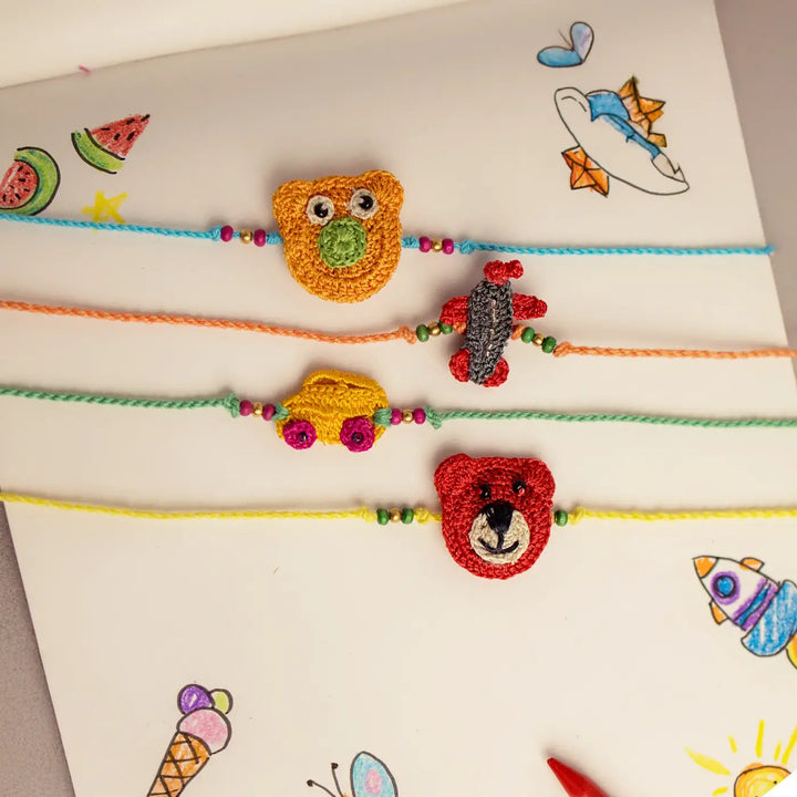 Handmade Crochet Toys And Animals Theme Kids Rakhi With Roli Chawal Set Of 4 - Flat Lay with Colorful Background